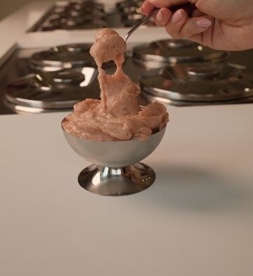 A spoon pulling a long stretch of gelato